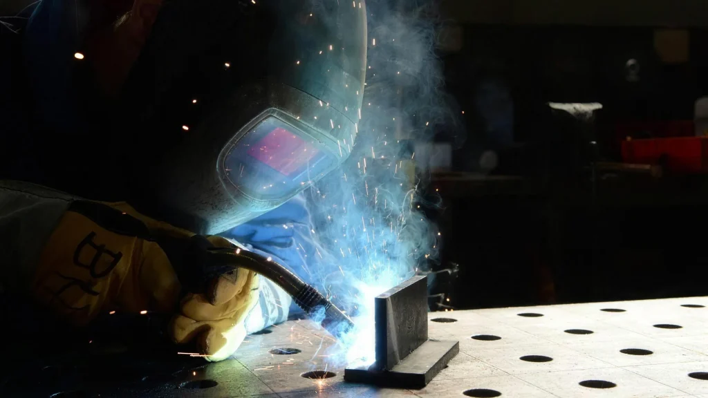 Metallbauer beim Schweißen mit Funkenflug in der Werkstatt